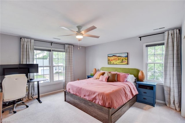 bedroom featuring baseboards, light colored carpet, ceiling fan, and visible vents