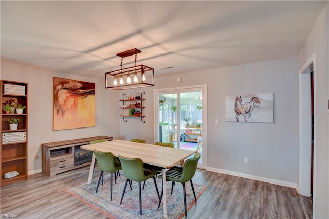 dining room featuring baseboards, wood finished floors, and visible vents