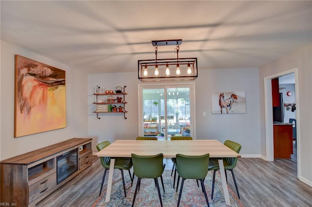dining space with baseboards and dark wood-type flooring
