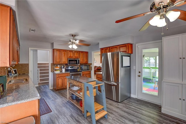 kitchen featuring decorative backsplash, a ceiling fan, visible vents, appliances with stainless steel finishes, and a sink