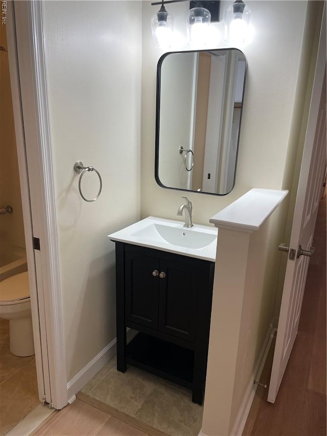 bathroom with vanity, baseboards, and toilet