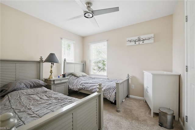 bedroom featuring a ceiling fan, baseboards, and light carpet