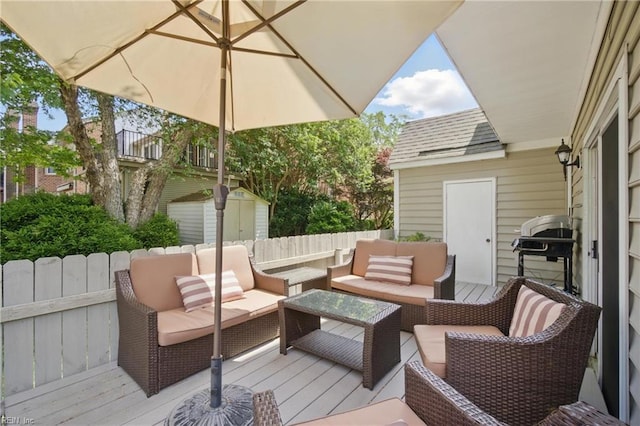 wooden deck featuring an outbuilding, outdoor lounge area, a storage shed, and grilling area