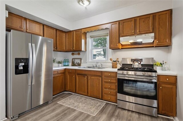 1312 E Norcova Dr, Norfolk, VA 23502 - kitchen featuring under cabinet range hood, stainless steel appliances, brown cabinets, and a sink