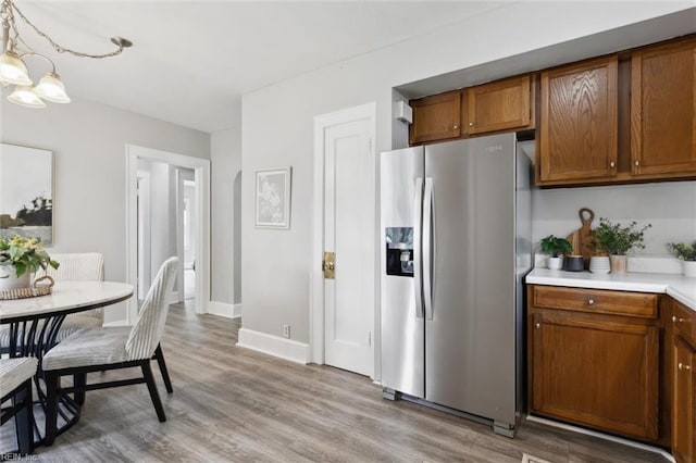 1312 E Norcova Dr, Norfolk, VA 23502 - kitchen featuring light wood-style floors, brown cabinets, light countertops, baseboards, and stainless steel fridge
