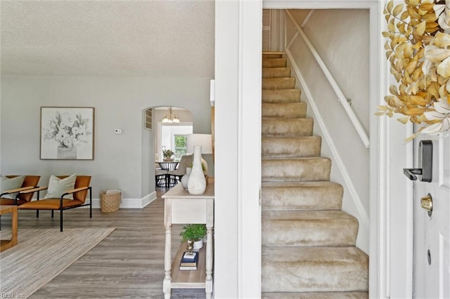 1312 E Norcova Dr, Norfolk, VA 23502 - stairway with wood finished floors, baseboards, a textured ceiling, a chandelier, and arched walkways