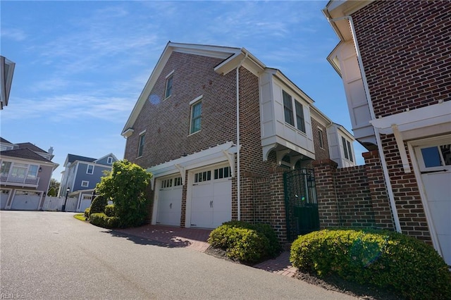 view of property exterior featuring a garage, fence, and brick siding