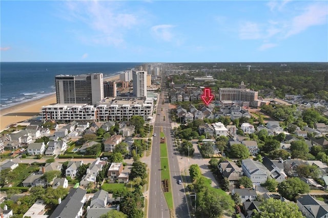 drone / aerial view featuring a water view, a residential view, and a beach view