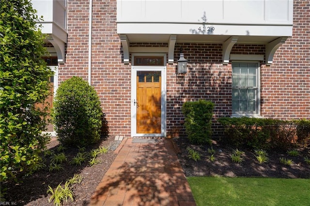 doorway to property featuring brick siding