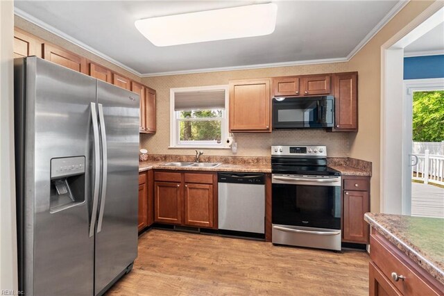 5013 Finn Rd, Virginia Beach, VA 23455 - kitchen featuring brown cabinetry, a sink, light wood-style floors, ornamental molding, and stainless steel appliances