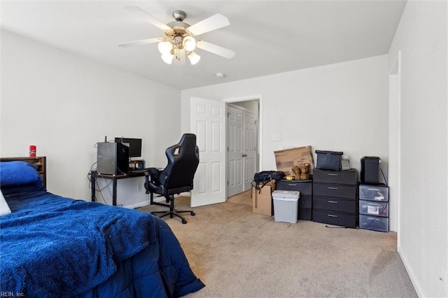 bedroom with a ceiling fan, baseboards, and light carpet