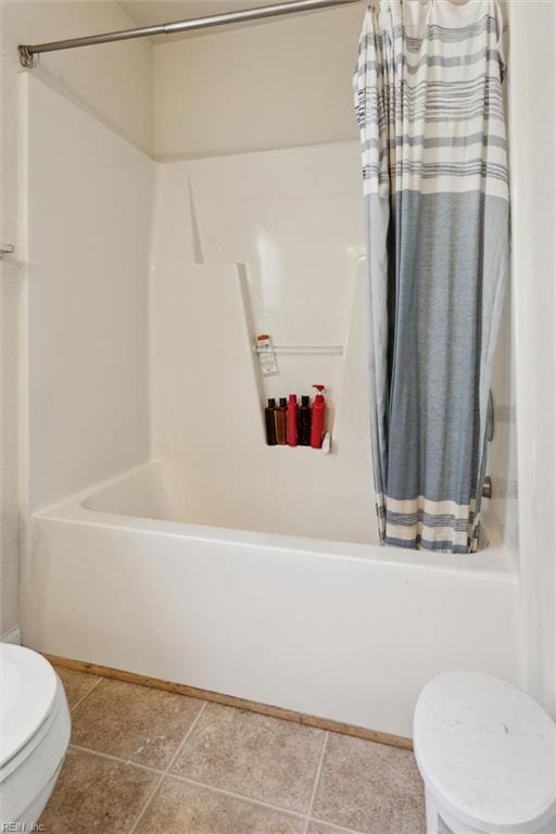 full bath with tile patterned flooring, shower / bath combo, and toilet