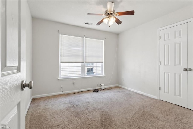 unfurnished room featuring carpet floors, a ceiling fan, baseboards, and visible vents