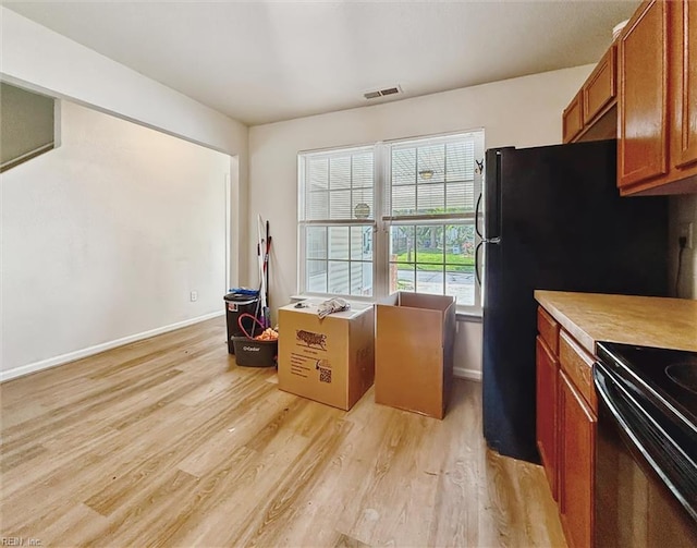 kitchen with visible vents, brown cabinetry, light wood-style floors, baseboards, and light countertops