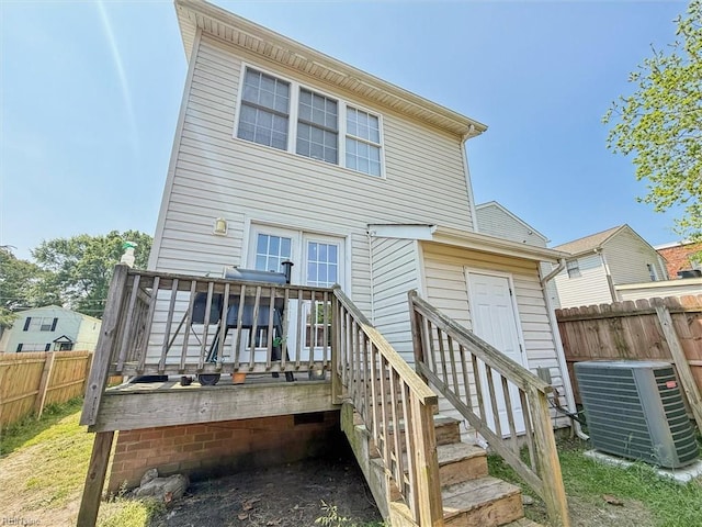 rear view of property featuring central AC, a deck, and fence