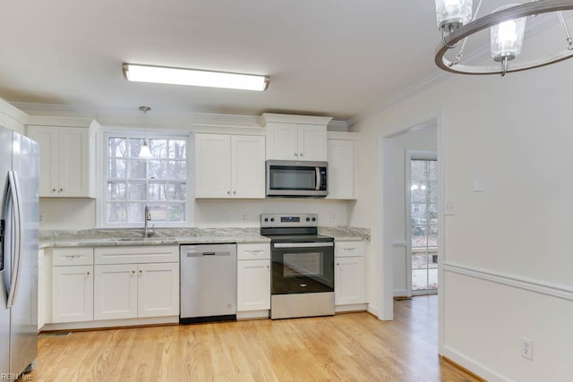 106 Running Man Trl, Yorktown, VA 23693 - kitchen with crown molding, light wood-type flooring, white cabinetry, a sink, and appliances with stainless steel finishes