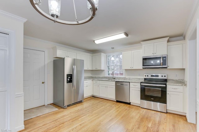 106 Running Man Trl, Yorktown, VA 23693 - kitchen featuring white cabinets, appliances with stainless steel finishes, ornamental molding, and light wood-type flooring