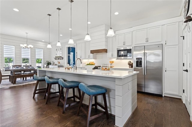 2245 Chamberino Dr, Virginia Beach, VA 23456 - kitchen with a notable chandelier, appliances with stainless steel finishes, light countertops, a kitchen breakfast bar, and dark wood finished floors