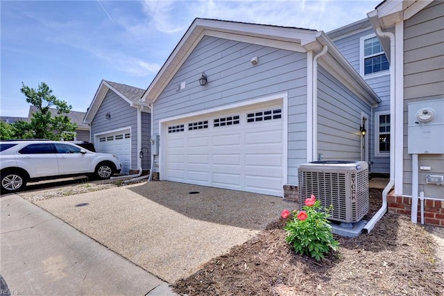 view of side of home featuring central air condition unit, driveway, and a garage