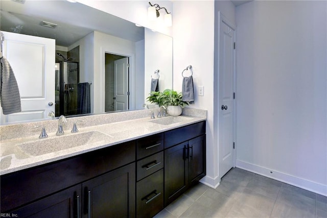 full bath featuring a sink, baseboards, a shower stall, and double vanity