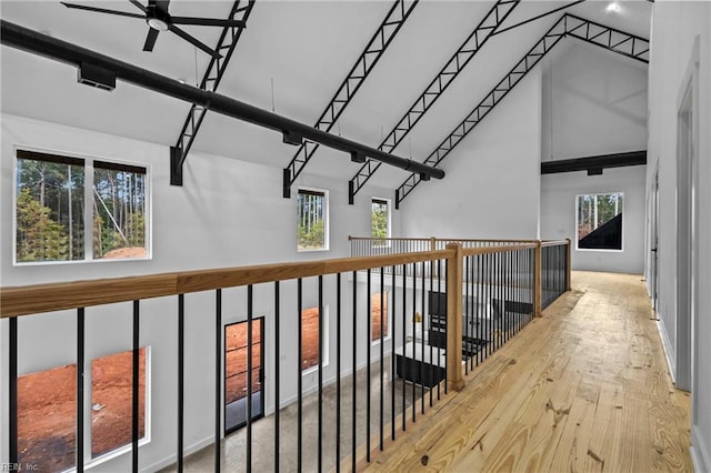 corridor with high vaulted ceiling and wood finished floors