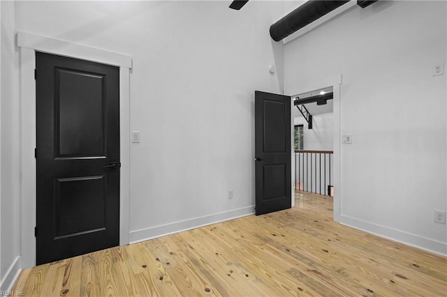 spare room with baseboards and hardwood / wood-style flooring