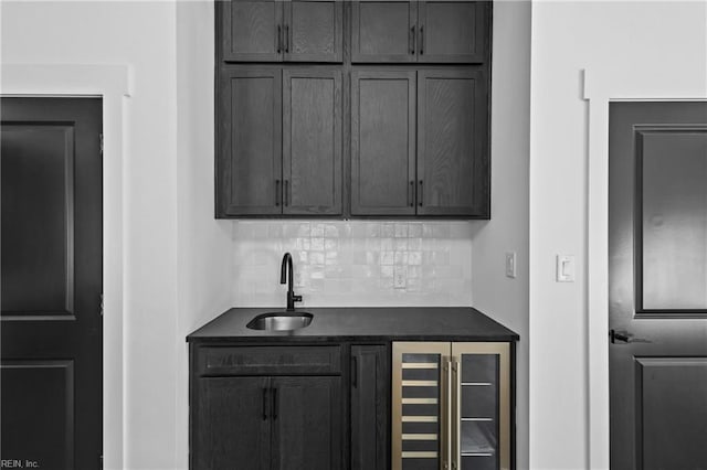 bar featuring beverage cooler, a sink, indoor bar, and tasteful backsplash