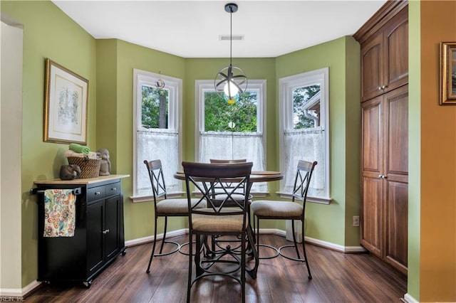 dining space with dark wood-style flooring and baseboards