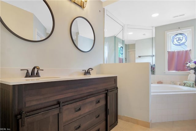 bathroom with tile patterned flooring, a bath, and double vanity