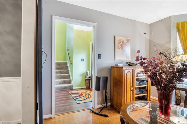 interior space featuring wood finished floors, stairway, and baseboards