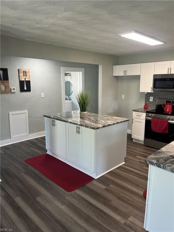 2622 Harrell Ave, Norfolk, VA 23509 - kitchen featuring appliances with stainless steel finishes, white cabinetry, dark wood-style flooring, dark stone counters, and baseboards