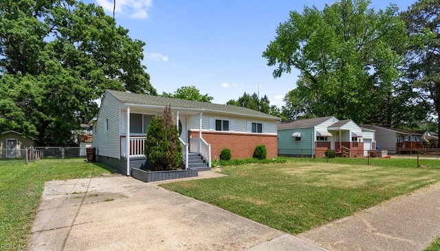 view of front of house featuring brick siding, fence, and a front lawn