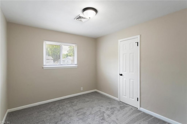 carpeted empty room featuring visible vents and baseboards