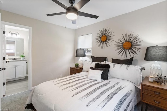 bedroom featuring a ceiling fan, multiple windows, a sink, and ensuite bath