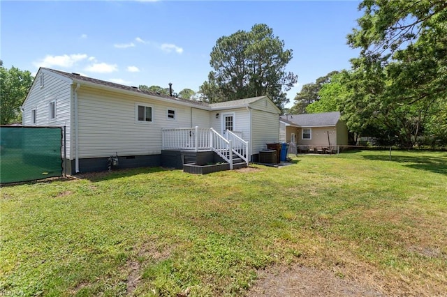 back of property featuring fence, a deck, central AC unit, crawl space, and a yard