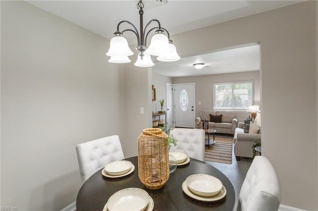 dining area featuring an inviting chandelier and baseboards