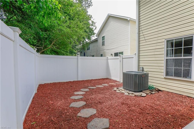 view of yard with a fenced backyard and central AC