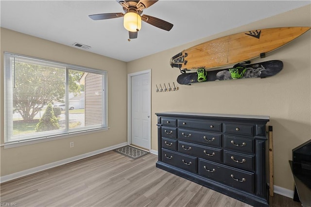 bedroom with baseboards, ceiling fan, light wood finished floors, and visible vents