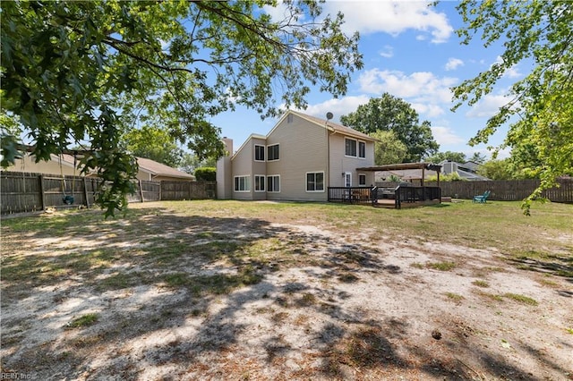 rear view of property with a wooden deck and a fenced backyard