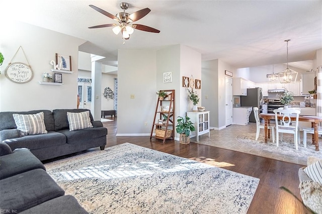 living area featuring baseboards, ceiling fan with notable chandelier, and wood finished floors