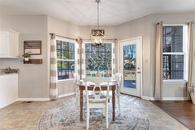 dining space with baseboards, an inviting chandelier, and visible vents