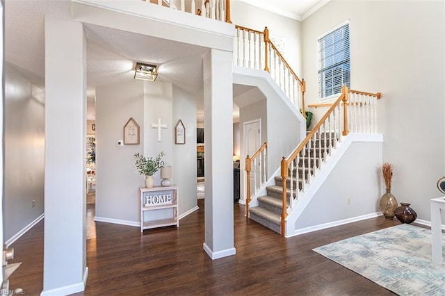 stairs featuring baseboards, a high ceiling, ornamental molding, and wood finished floors