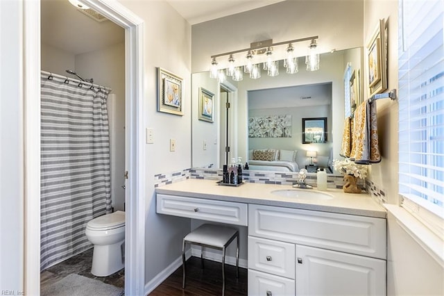 ensuite bathroom with vanity, connected bathroom, visible vents, and toilet