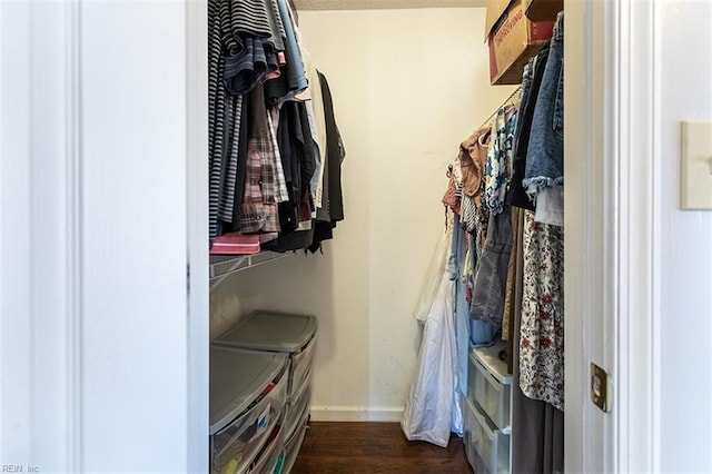 walk in closet featuring dark wood-type flooring and washer and clothes dryer