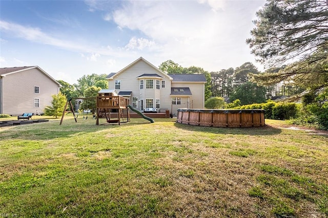 back of property featuring a lawn, a playground, and a covered pool