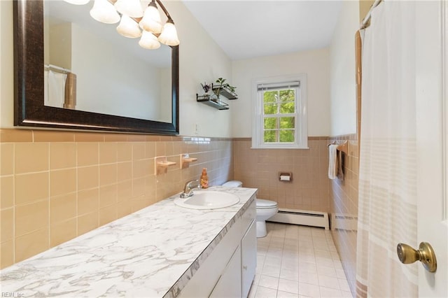 full bathroom with vanity, tile patterned flooring, toilet, baseboard heating, and a wainscoted wall