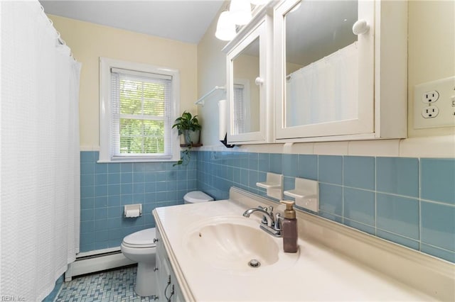 bathroom featuring baseboard heating, vanity, toilet, tile patterned floors, and tile walls