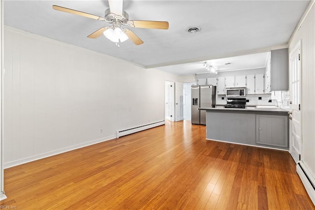 kitchen with visible vents, appliances with stainless steel finishes, baseboard heating, and dark countertops