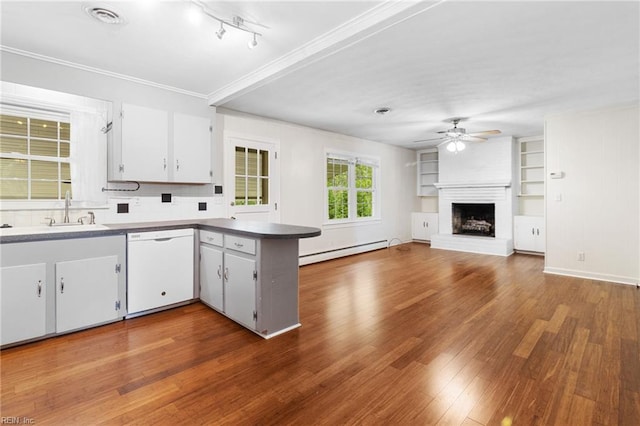 kitchen featuring a ceiling fan, wood finished floors, dishwasher, a sink, and a baseboard heating unit