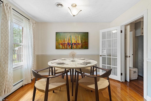 dining room featuring baseboard heating and wood finished floors